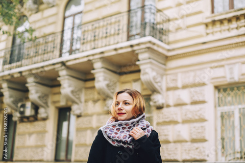 Portrait of serious Caucasian woman wearing scarf near building