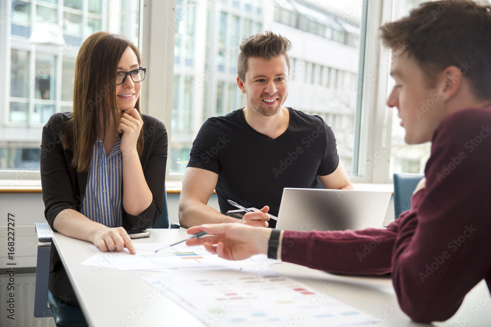 Business People Discussing Over Document In Office Business People Discussing Over Document In Office