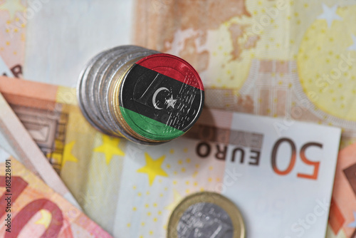euro coin with national flag of libya on the euro money banknotes background.