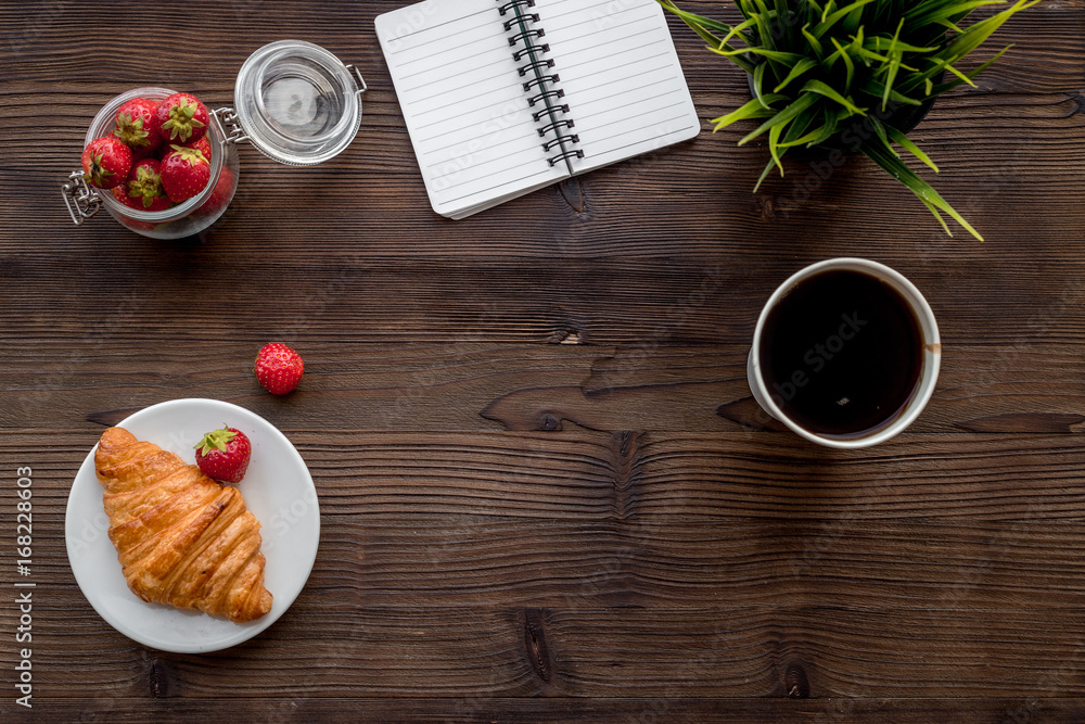 Light summer lunch. Coffee, strawberry, croissant on wooden background top view copyspace