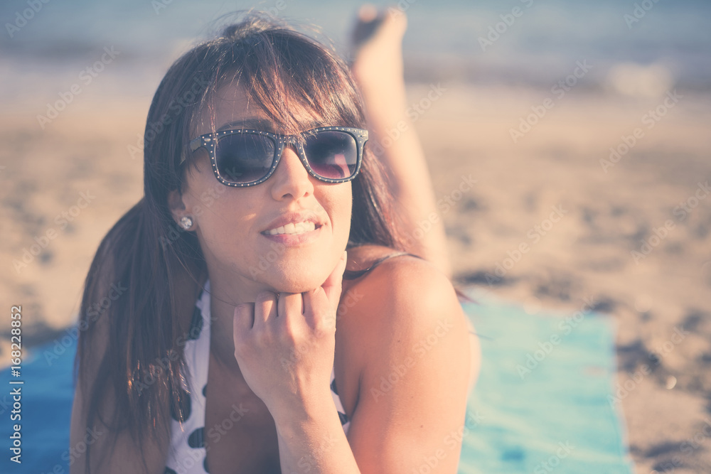 Caucasian woman laying on beach blanket Caucasian woman laying on beach blanket