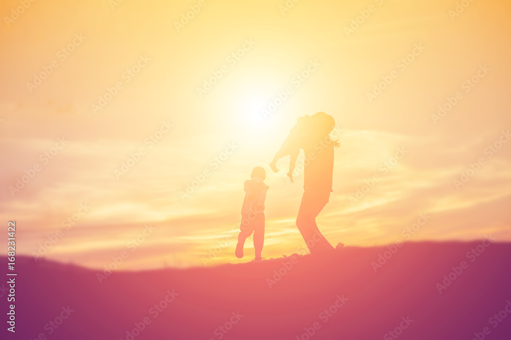 Silhouettes of father and little daughter walking at sunset