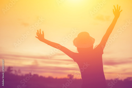 Silhouette of woman praying over beautiful sky background © chaunpis