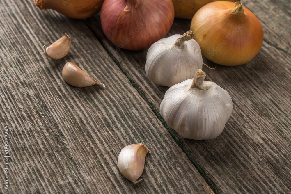 Garlic and onion on an old table, vegetables Garlic and onion on an old table, vegetables