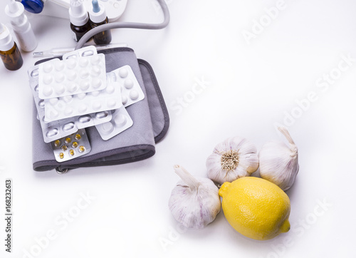 Lemon and garlic versus druga and pills on the white background photo