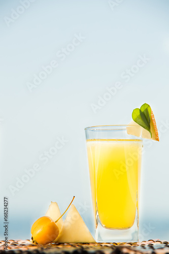 Organic melon lemonade with mineral water. Cocktail with melon juice and ice with sea on background.