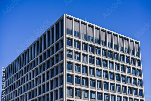 Rectangle Building With Lots Of Big Glass Windows And Blue Sky Background
