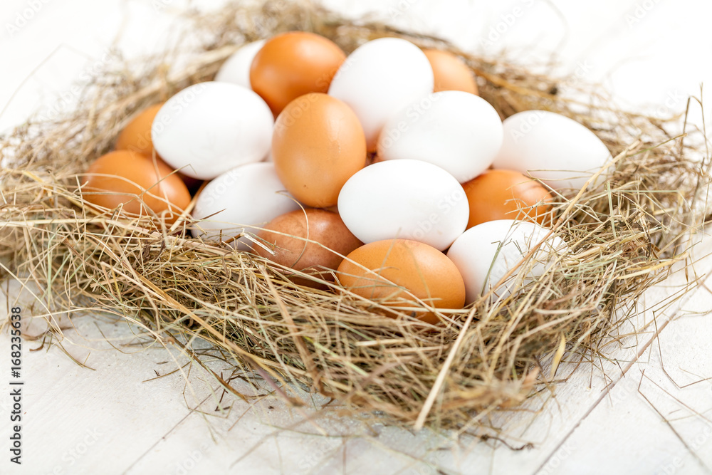 Fresh country eggs with straw on rustic wooden white table Fresh country eggs with straw on rustic wooden white table
