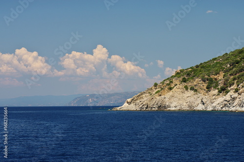 Athos peninsula, Greece. Steep edges of Athos peninsula. Blue sky with white clouds over the azure sea. © wojtekmt