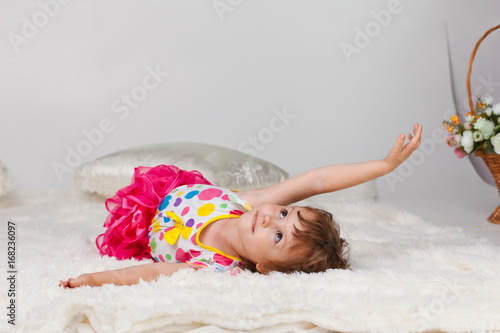 Девочка лежит на мохнатом пледе