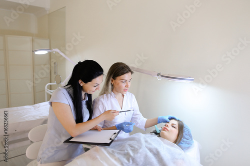 Female eyebrow tattoo master teaches girl student to work with c