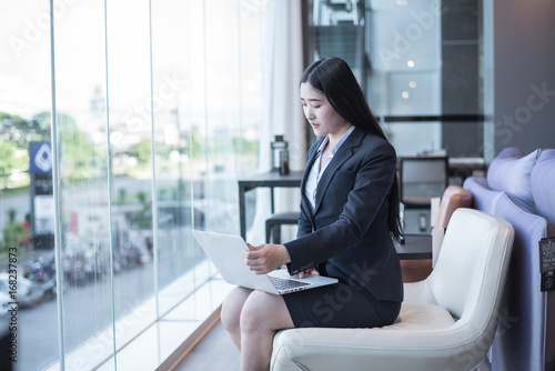 Free Download Asian young business freelance woman happiness working online business with laptop and cell phone in cafe shop. Working concept. - GFXLoad