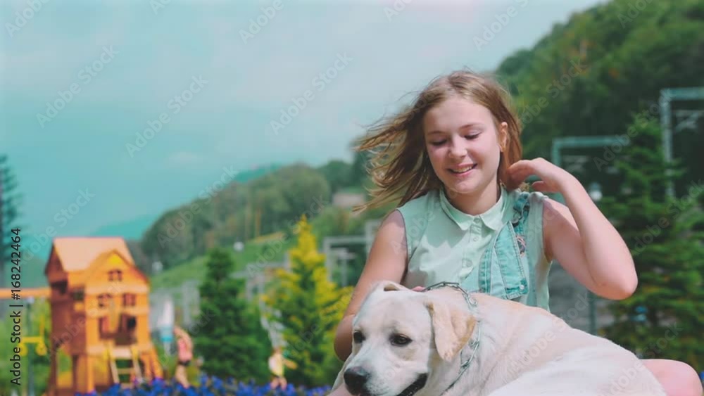 A teenage girl is playing with her favorite dog in the park. He is a devoted friend of man. A teenage girl is playing with her favorite dog in the park. He is a devoted friend of man.