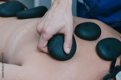 Young woman having stone massage in spa salon. Healthy lifestyle.Stone therapy photo