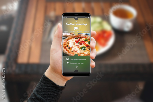 Φωτογραφία Man hand with phone in restaurant, ordering food online