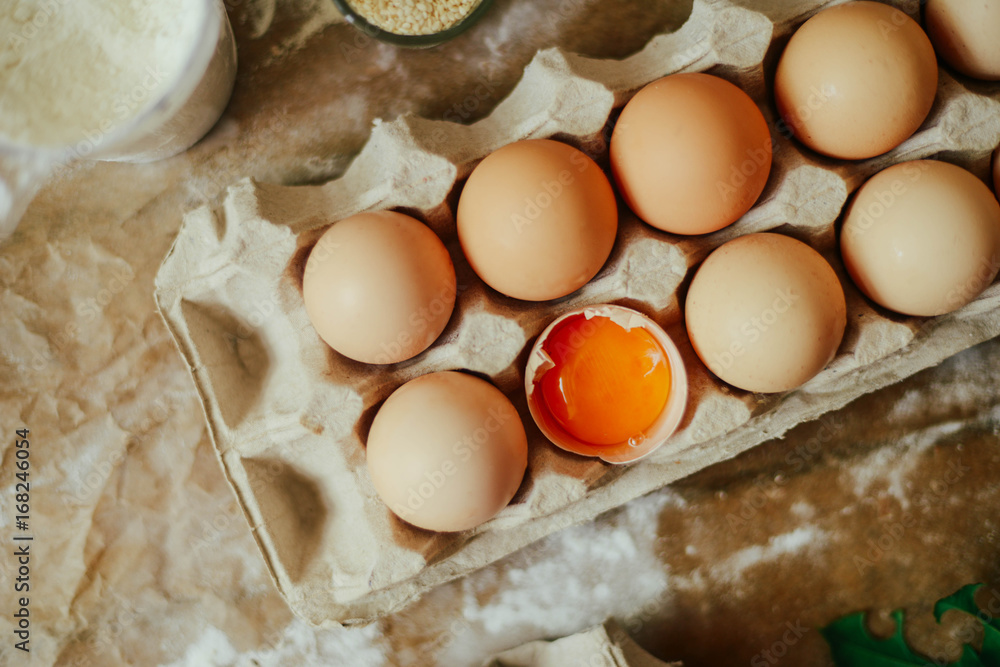 hands cut cookie from raw dough on a wooden table. Healthy baking ingredients - flour,  butter, eggs, biscuits over a wooden table background.