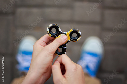 Boy playing with fidget spinner, close up. Trendy gadgets, entertainment concept