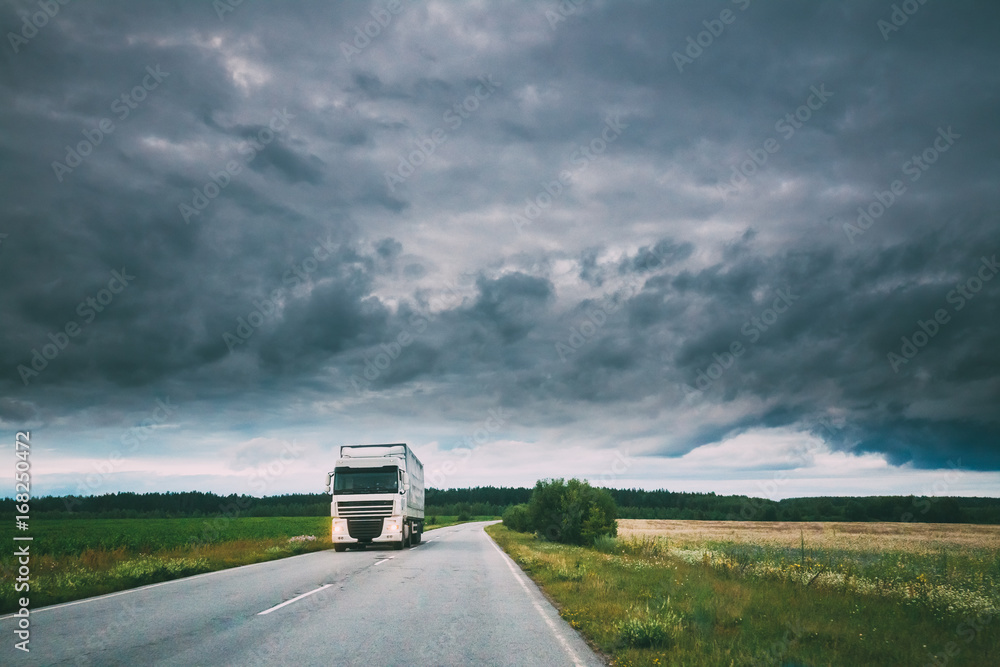 Truck, Tractor Unit, Prime Mover, Traction Unit In Motion On Country Road, Freeway In Europe. Cloudy Sky Above The Asphalt Motorway, Highway.