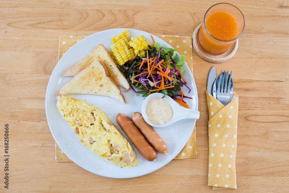 Top view of omelet with hot dog, croissants, cereals and fruits on wooden table. Balanced diet.