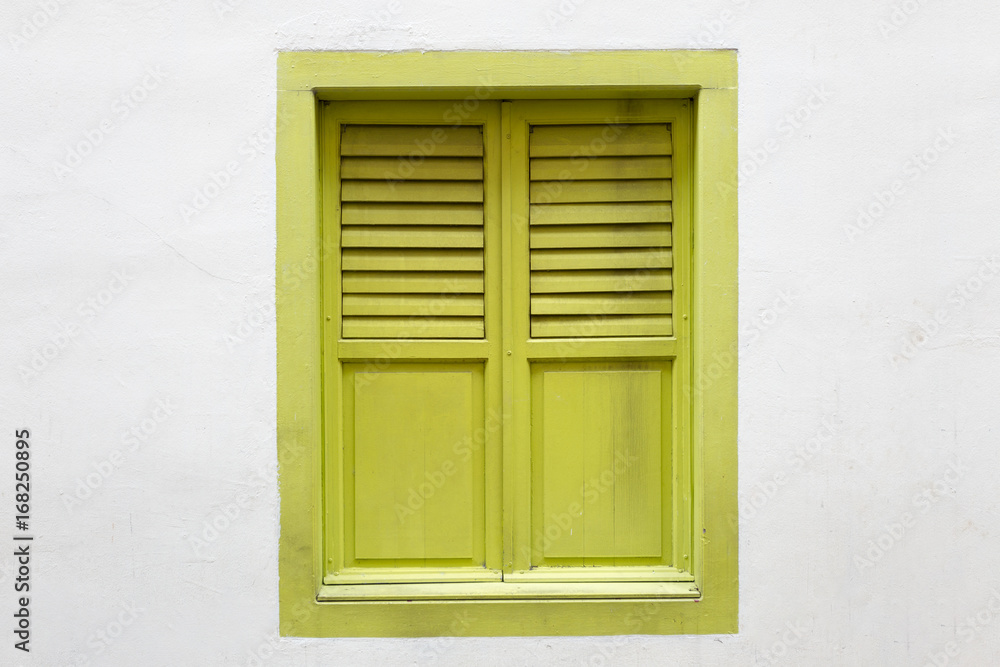 Green wooden window is classic vintage style on white cement wall background.