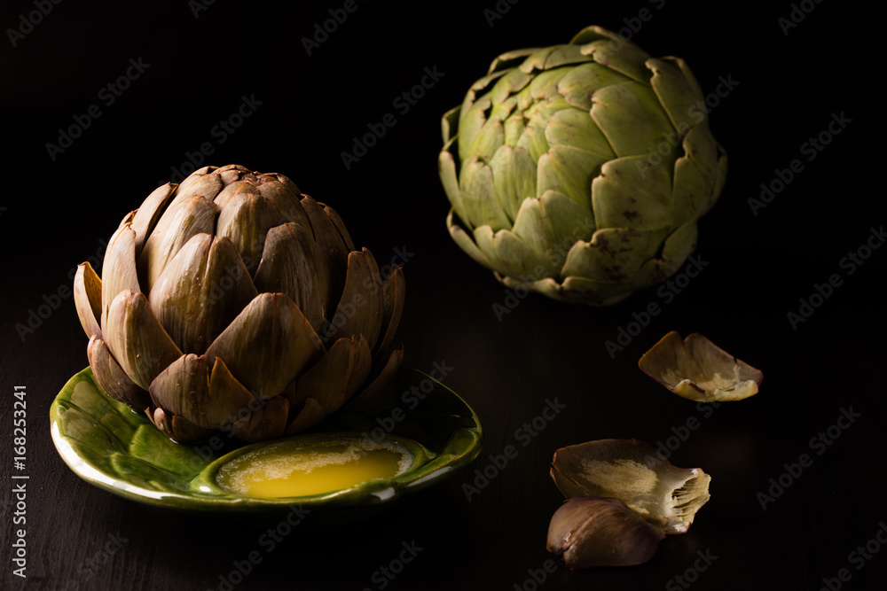 Obraz premium Artichoke for Dinner on plate with leaves on the table