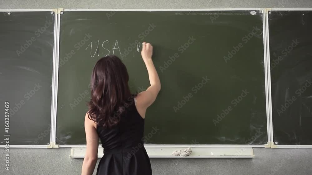 A young girl writes chalk on the audience board A young girl writes chalk on the audience board