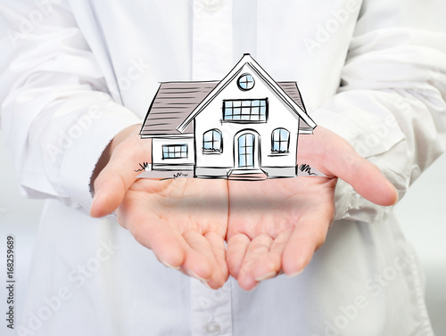 The Architecture, building, house,home,construction, real estate and property concept - close up of hands holding house or home model.Female hand holding house ,real estate agent.