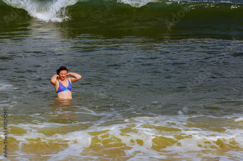 Fototapeta Naklejka Na Ścianę i Meble -  beautiful brunette woman run blue ocean