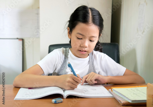 Εκτύπωση καμβά Happy young student Asian pre teens girl doing homework indoors at home countryside