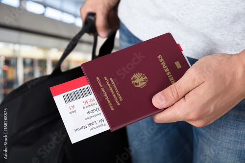 Person With Luggage Holding Passport And Boarding Pass Tickets