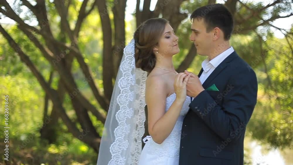 Beautiful bride and groom walking in the park before the wedding ceremony Beautiful bride and groom walking in the park before the wedding ceremony