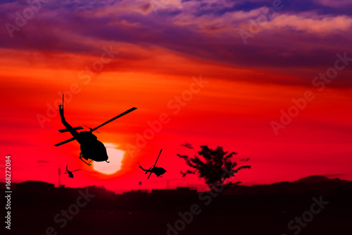 silhouette of helicopter on sunset with copy space add text ( Concept stop hostilities To peace)