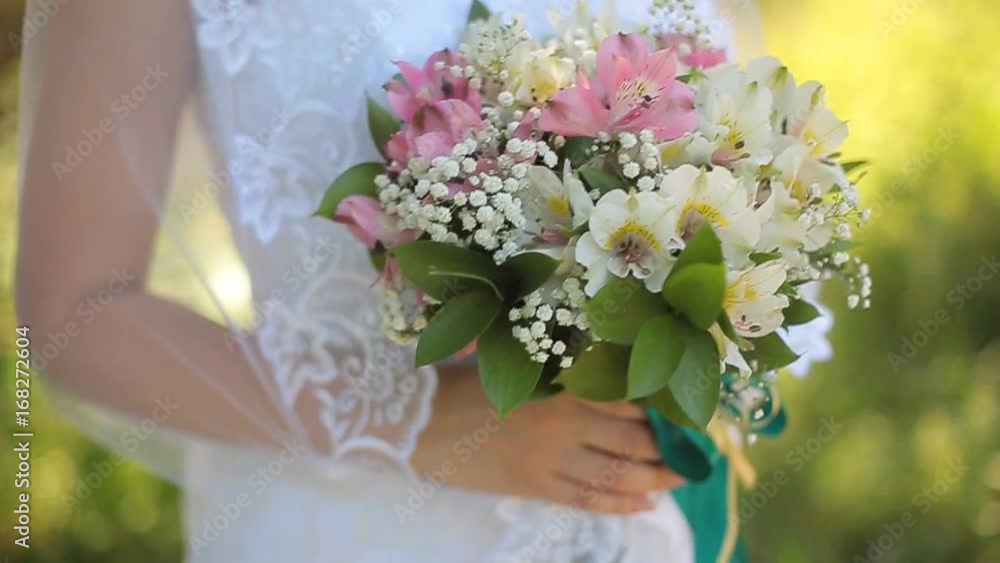Beautiful bride stands near the lake and waits for the groom