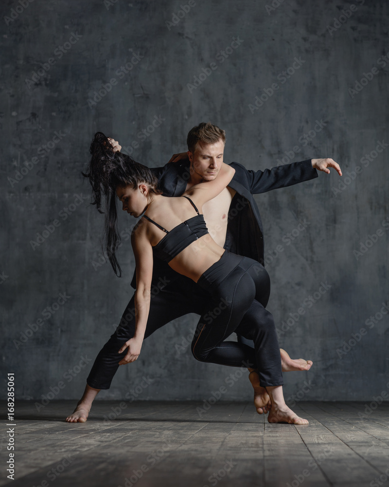 Couple of ballet dancers posing in studio