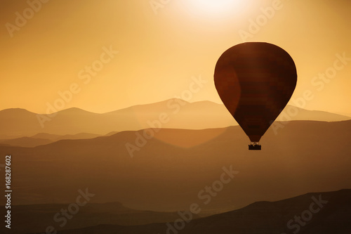 Silhouette of balloons with sunrise in background, aerial view