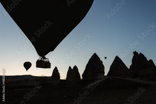 Silhouette of balloons with sunrise in background, aerial view