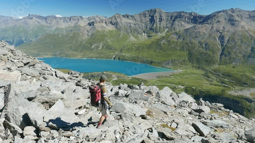 Woman walking in high altitude rocky mountain landscape. Summer adventures on the Italian French Alps. Slow motion.