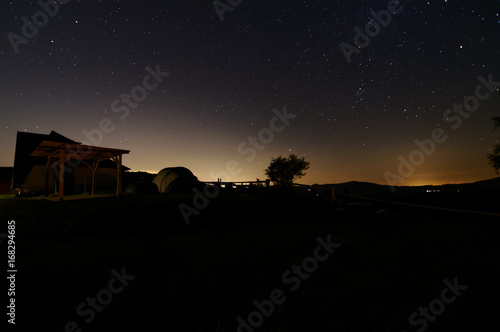 Shelter on top of the mountain, night view with a lot of stars on the sky.
