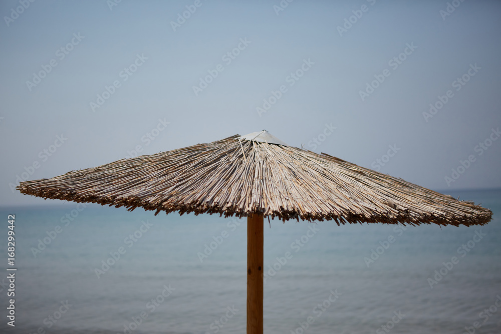 Straw beach umbrella against the sky.