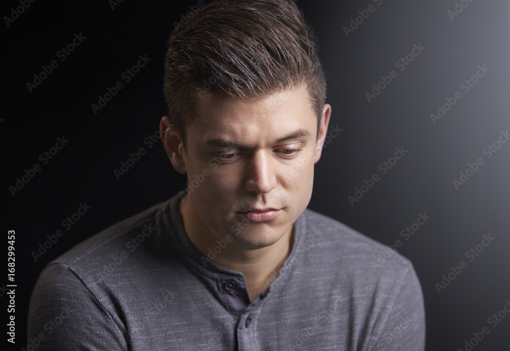 Portrait of a worried young man looking down Portrait of a worried young man looking down