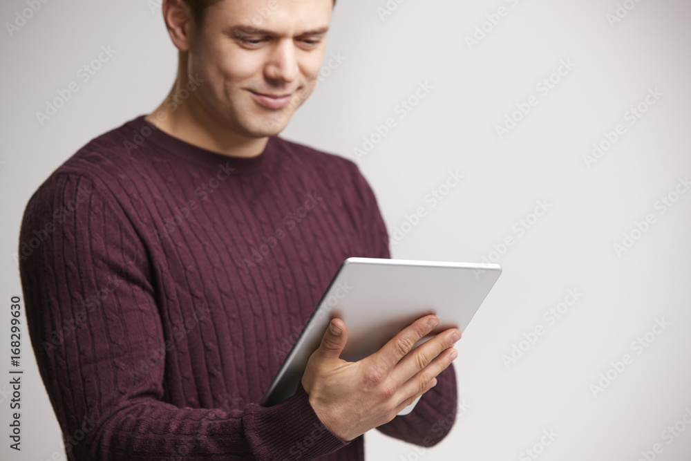 Smiling young white man using a tablet computer Smiling young white man using a tablet computer
