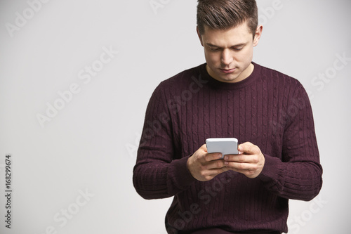 Portrait of a young white man using a smartphone
