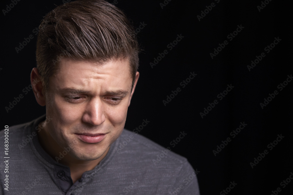 Portrait of crying young white man looking down Portrait of crying young white man looking down