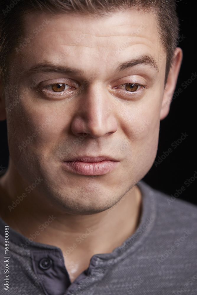 Vertical portrait of crying young white man looking down Vertical portrait of crying young white man looking down