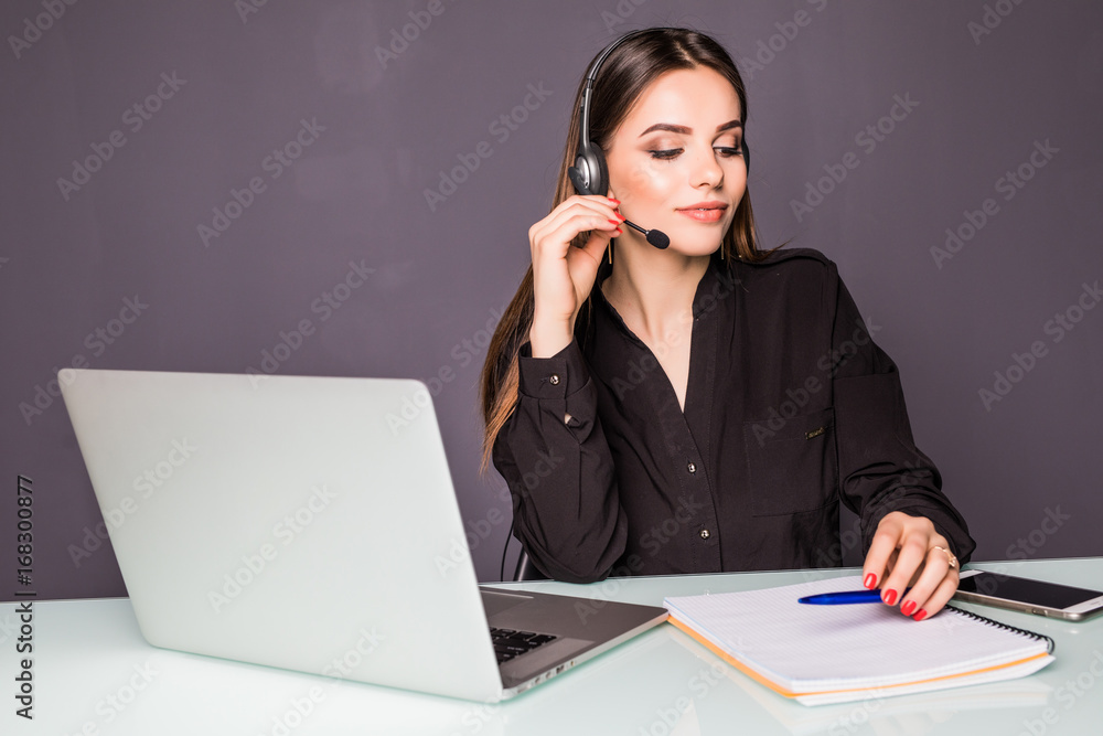 Portrait of beautiful business woman working at her desk with headset and laptop in office Portrait of beautiful business woman working at her desk with headset and laptop in office