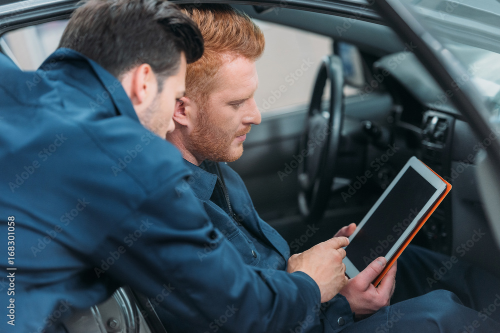 Car mechanics using digital tablet Car mechanics using digital tablet