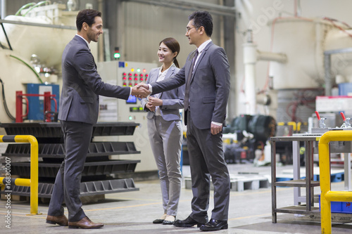 Business people shaking hands in the factory photo