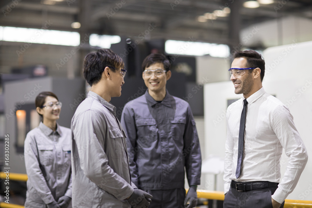 Businessman and engineers talking in the factory Businessman and engineers talking in the factory