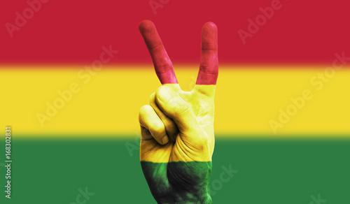 Bolivia national flag painted onto a male hand showing a victory, peace, strength sign