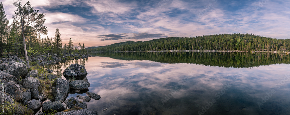 Fototapeta premium Panorama of calm lake at Lapland in midnight sun time. Rocks in front.